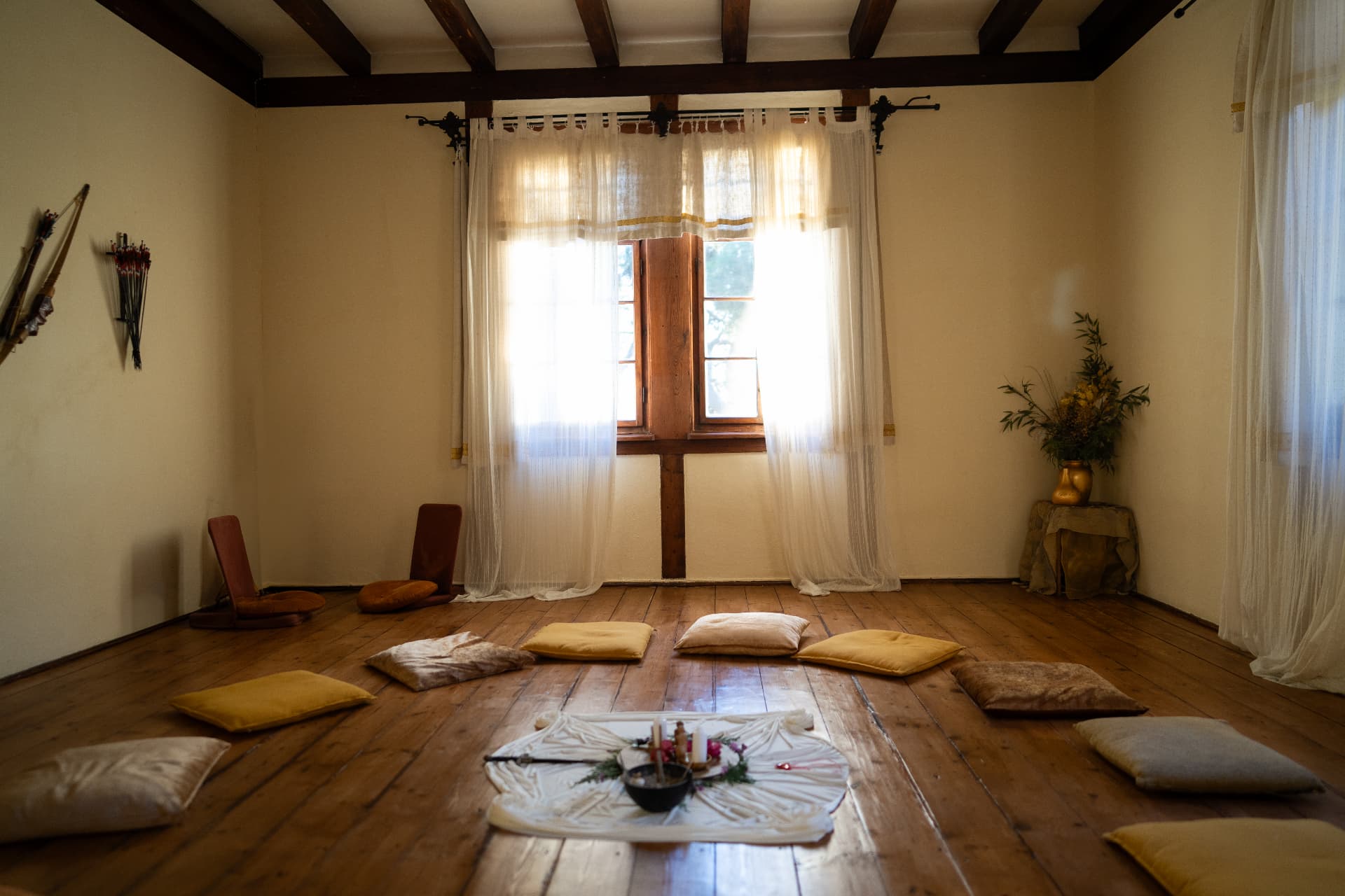 The temple room with wooden floors, cushions and an altar