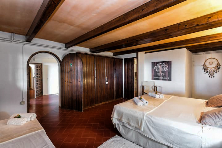 Bedroom with wooden wardrobes and beamed ceiling