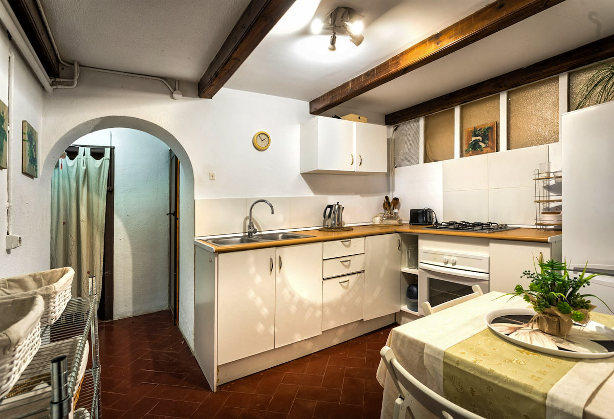 Kitchen with gas stove, oven and arched doorway